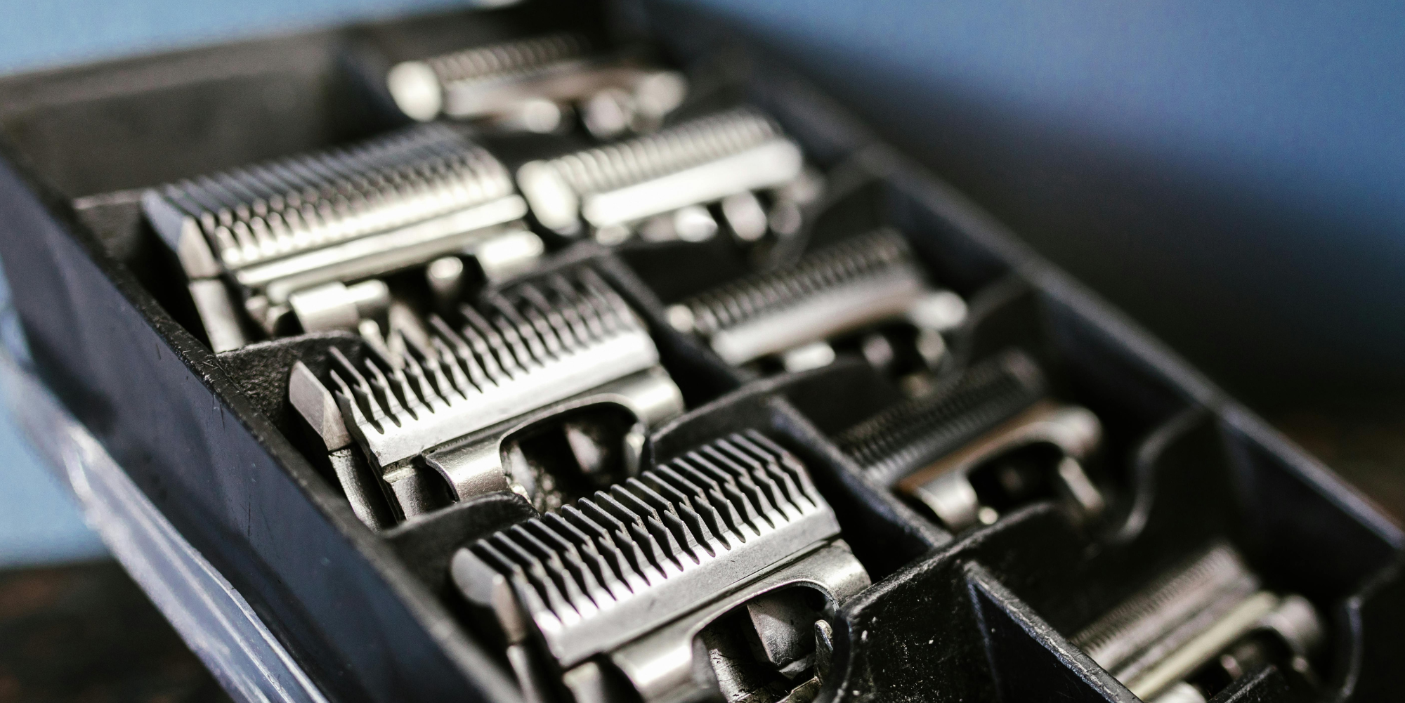 Set of clipper blades in a black case on a blue background